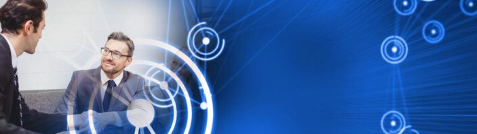 Dois homens de terno apertando as mãos em um ambiente profissional com sobreposição de gráficos digitais circulares em tons de azul.